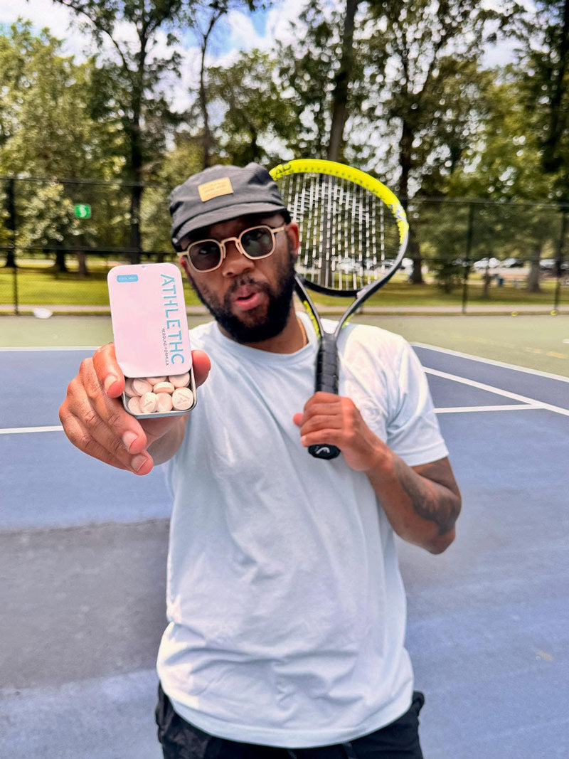 Tennis player holding a tin of rebound THC and CBD microdose mints.