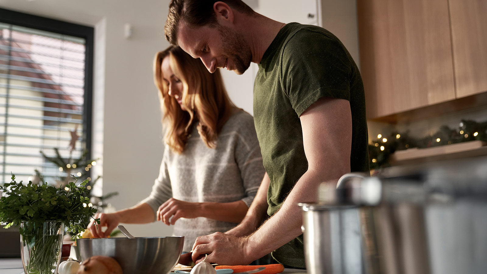 Man and woman preparing food together in a kitchen