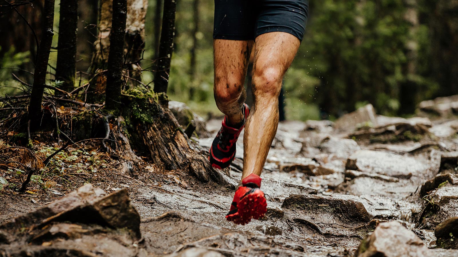 Man trail running on a muddy and rocky trail