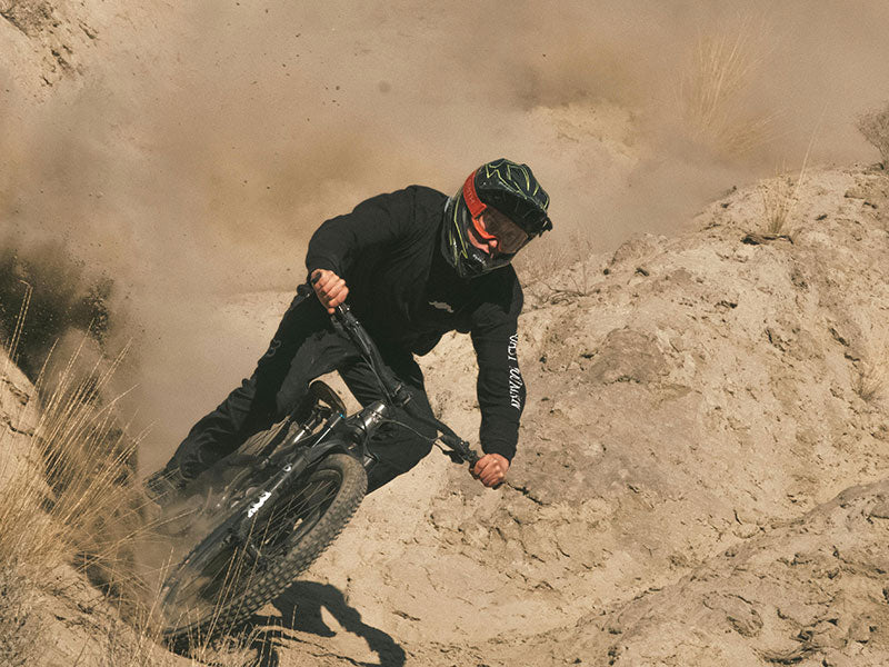 Mountain biker riding down a dusty hill