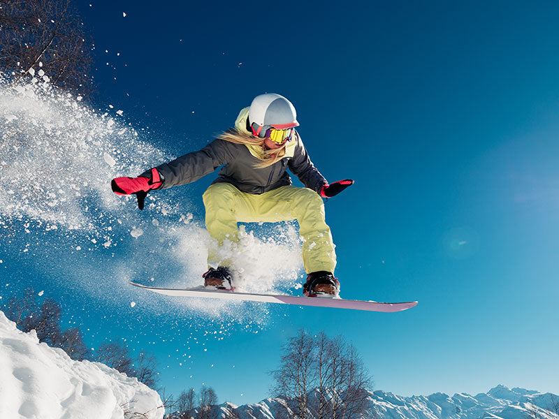 Woman snowboarder going off a jump